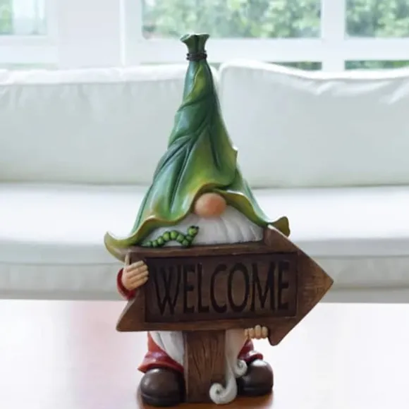 Långskäggig jultomte som håller en välkomstskylt